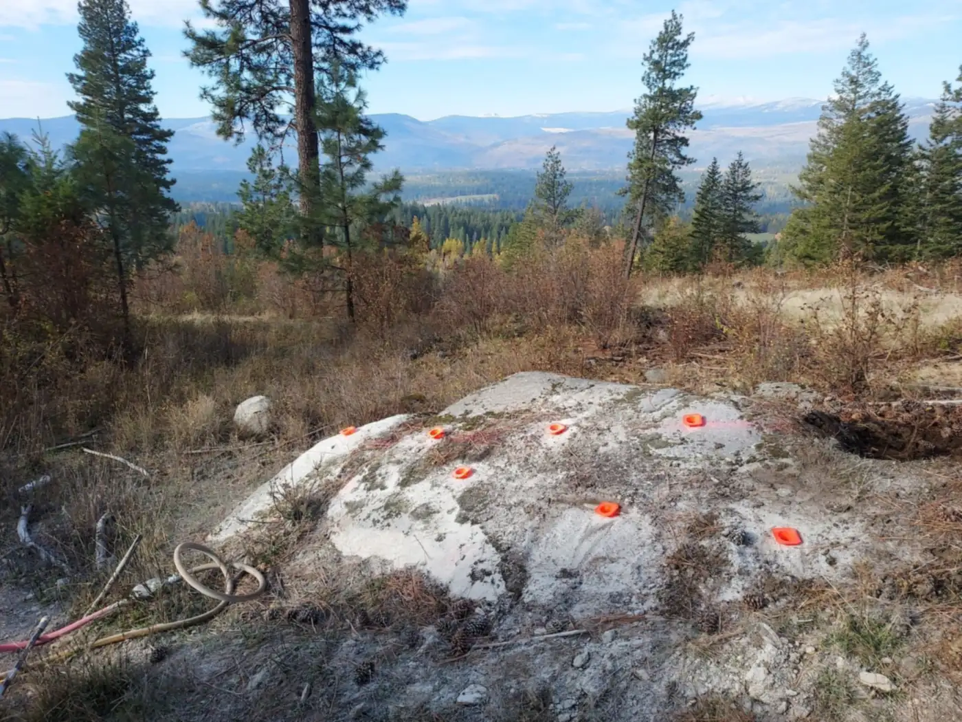 Forest road blocked by buried rock before blasting, Idaho